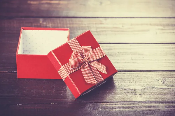 Red gift box on wooden table. — Stock Photo, Image