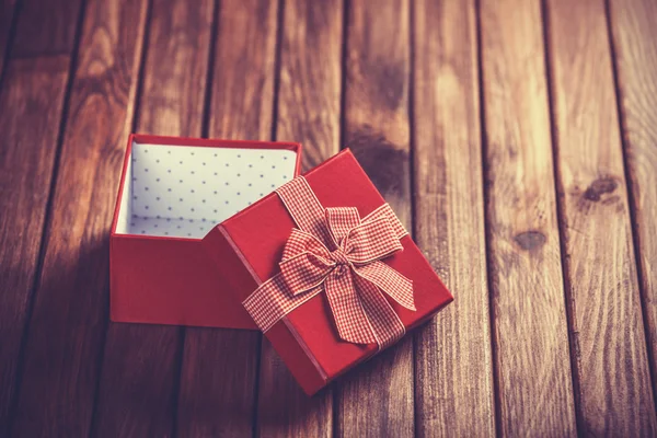 Red gift box on wooden table. — Stock Photo, Image