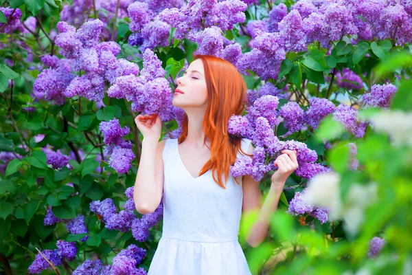 Redhead girl near lilac tree in the garden. — Stock Photo, Image