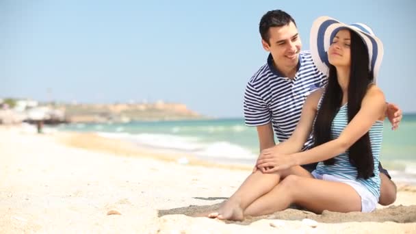 Young couple on the beach in summer day. — Stock Video