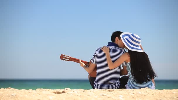 Young couple on the beach in summer day. — Stock Video