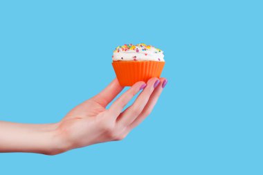 el mavi renkli cupcake tutarak