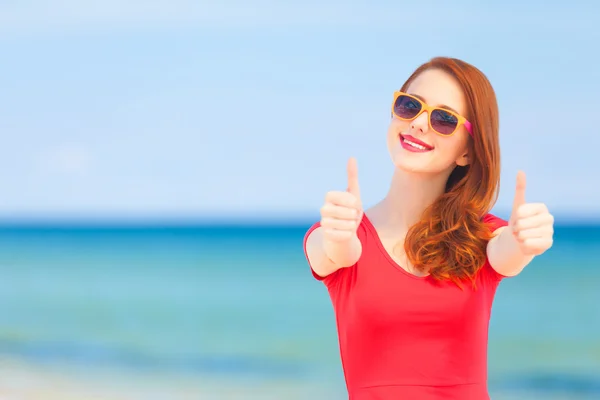 Ragazza rossa con gli occhiali da sole sulla spiaggia — Foto Stock