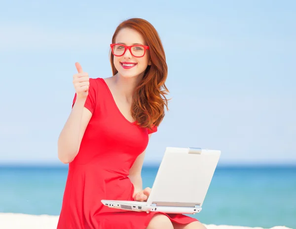 해변에서 노트북으로 안경에 빨간 머리 소녀 — 스톡 사진