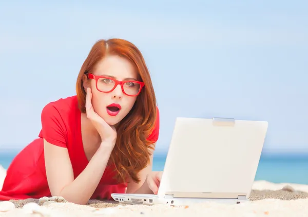 Redhead girl in the glasses with notebook on the beach — Stock Photo, Image