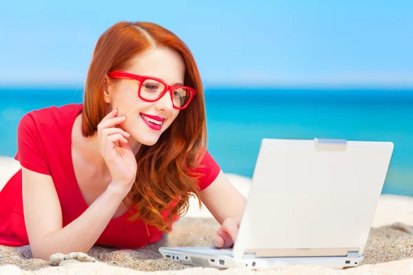 Redhead girl in the glasses with notebook on the beach — Stock Photo, Image