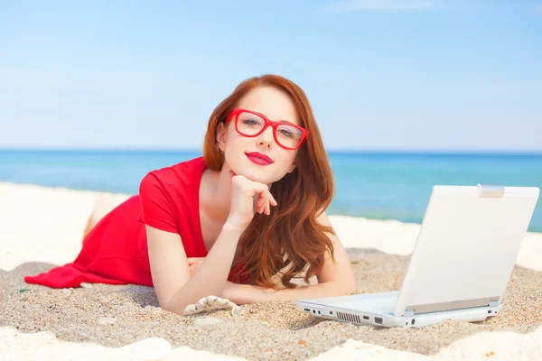 Redhead girl in the glasses with notebook on the beach — Stock Photo, Image