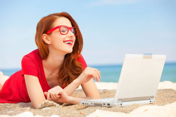 Redhead girl in the glasses with notebook on the beach — Stock Photo, Image