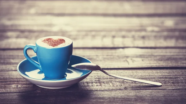 Coupe de café avec coeur en forme sur une table en bois . — Photo