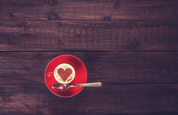 Tazza di caffè con cuore sagomato su un tavolo di legno . — Foto Stock