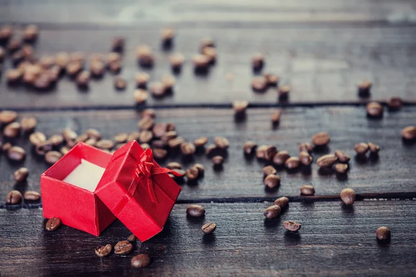 Red gift box and coffee on wooden table. — Stock Photo, Image