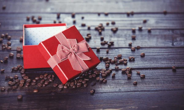 Röd presentask och kaffe på träbord. — Stockfoto