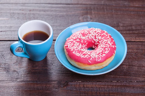 Donuts and coffee on wooden table. — Stock Photo, Image