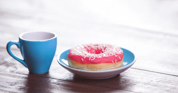 Donuts and coffee on wooden table. — Stock Photo, Image