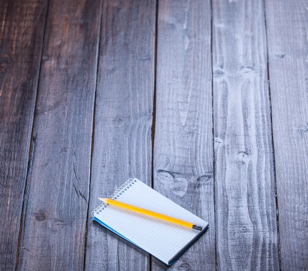 Caderno e lápis sobre mesa de madeira . — Fotografia de Stock