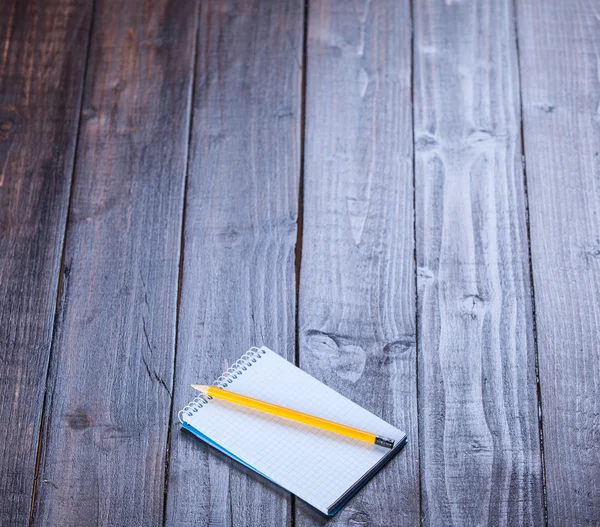 Notebook and pencil on wooden table. Stock Picture