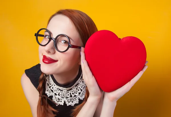Nerd κοκκινομάλλα κοπέλα με σχήμα καρδιάς σε κίτρινο backgorund. — Φωτογραφία Αρχείου