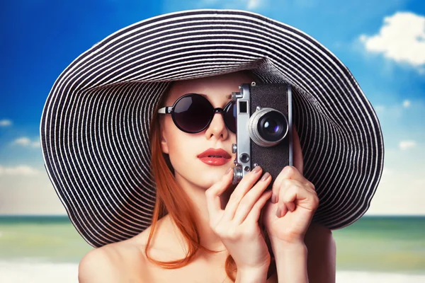 Pelirroja con cámara retro en la playa — Foto de Stock