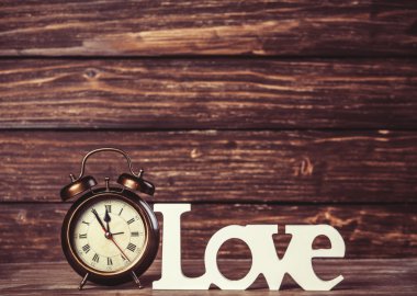 ahşap masa üzerinde kelime aşk ile saat.