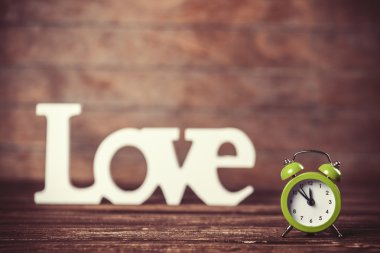 ahşap masa üzerinde kelime aşk ile saat.