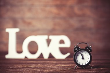 ahşap masa üzerinde kelime aşk ile saat.
