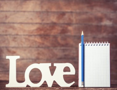 kalem ve defter kelime ile ahşap arka plan üzerinde seviyorum.