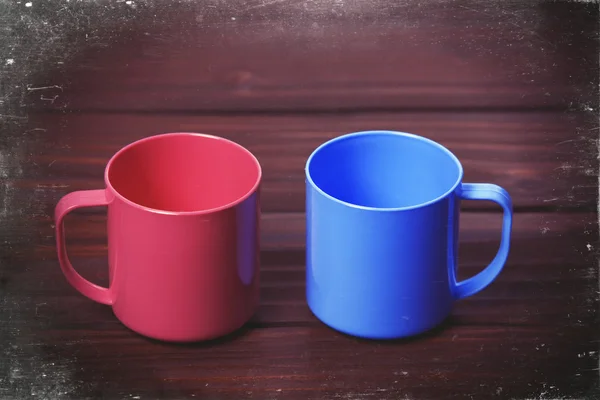 Dos copas de color en la mesa de madera . — Foto de Stock