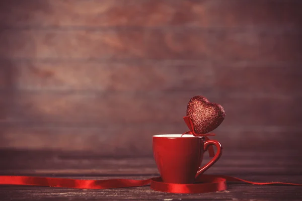 Filiżanka kawy z serca kształt zabawki na drewnianym stole. — Zdjęcie stockowe