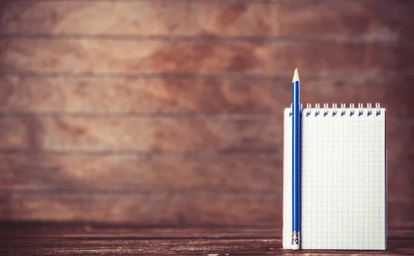 Notebook with pencil on wooden background. — Stock Photo, Image