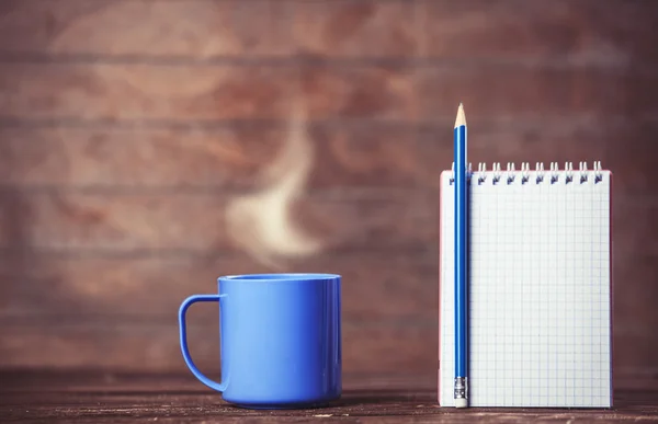 Tazza di caffè e taccuino su sfondo di legno. — Foto Stock