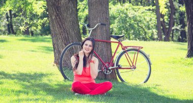 esmer kız parkta kahve ve bisiklet üzerinde