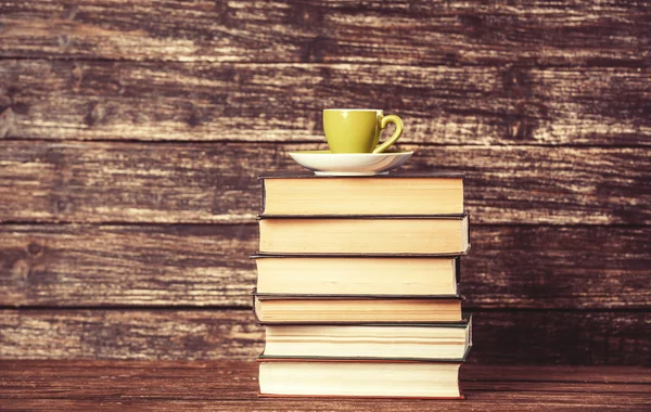 Boeken en kopje koffie op houten achtergrond. — Stockfoto