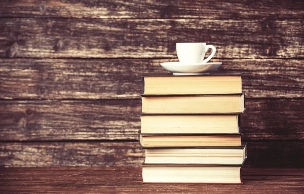 Books and cup of coffee on wooden background. — Stock Photo, Image