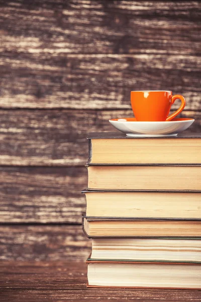 Boeken en kopje koffie op houten achtergrond. — Stockfoto