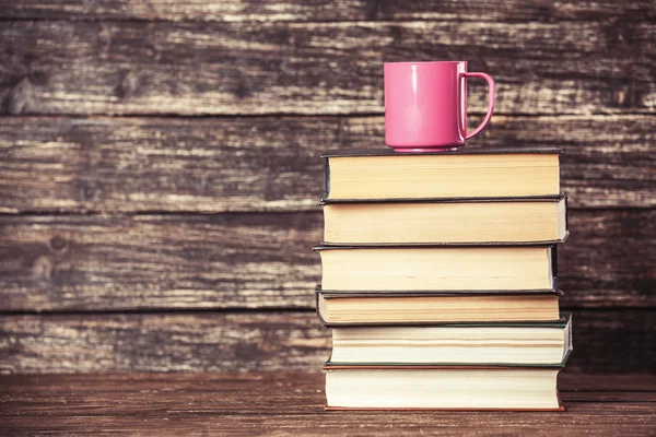 Libri e tazzina di caffè su fondo di legno . — Foto Stock