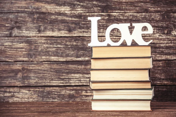 Palavra de amor e livros sobre mesa de madeira . — Fotografia de Stock