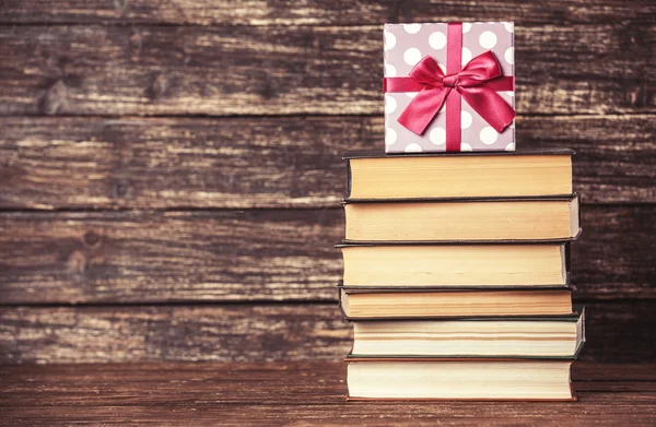 Geschenk und Bücher auf Holztisch. — Stockfoto