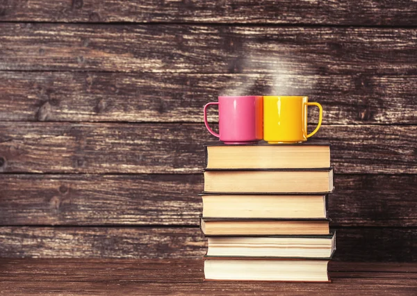 Twee kopjes en boeken op achtergrond. — Stockfoto