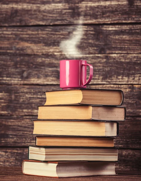 Boeken en kopje koffie op houten achtergrond. — Stockfoto