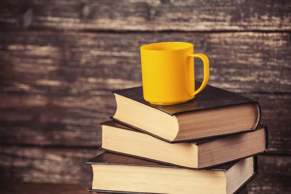 Libros y taza de café sobre fondo de madera . —  Fotos de Stock