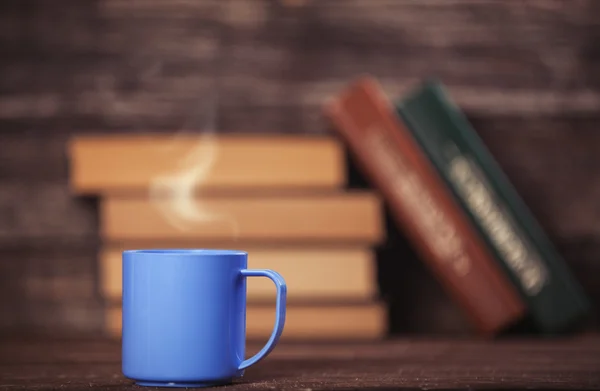 Книги и чашка кофе на деревянном фоне . — стоковое фото