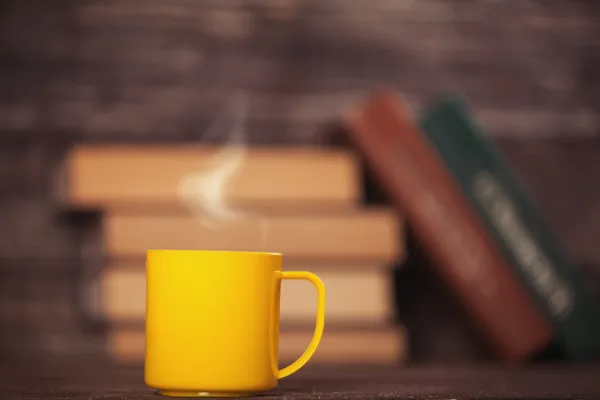 Libros y taza de café sobre fondo de madera . —  Fotos de Stock