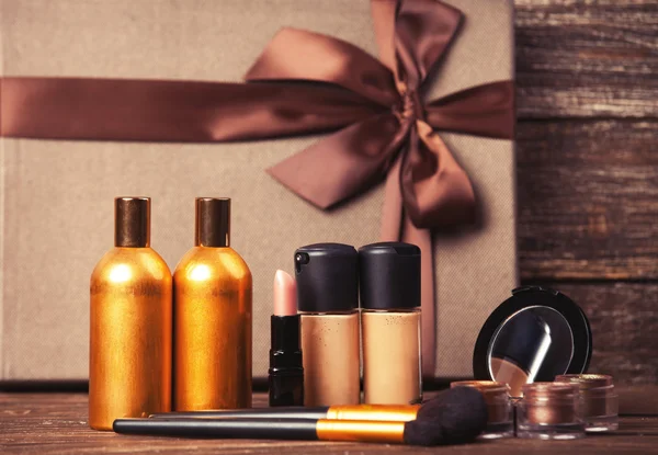 Cosmetics and gift box on wooden table. — Stock Photo, Image