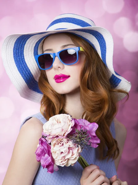 Redhead girl with flowers on pink background. — Stock Photo, Image