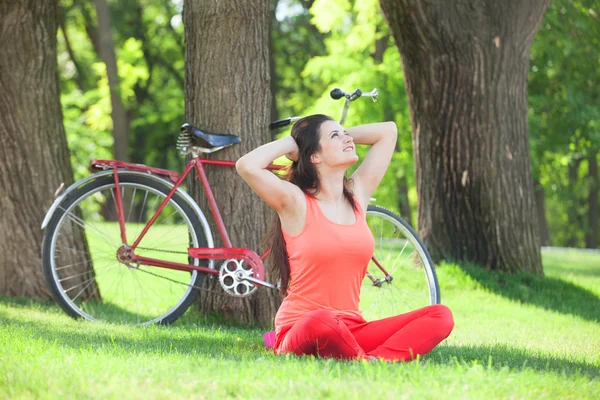 Happy girl in the park with bicycle on background. — Stock Photo, Image