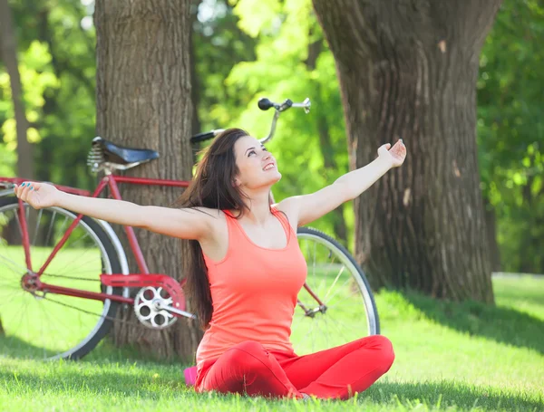 Happy girl in the park with bicycle on background. — Stock Photo, Image