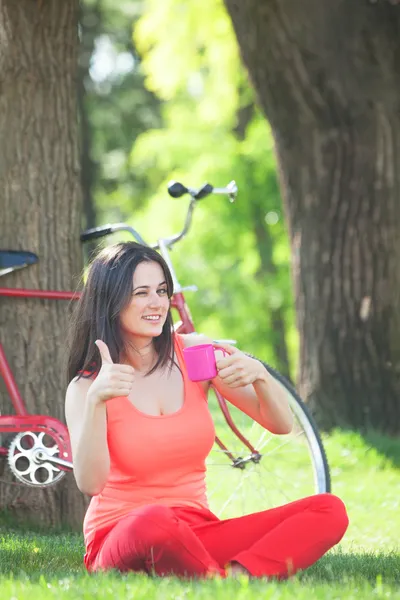 갈색 머리 소녀에 자전거와 공원에서 커피 한잔 — 스톡 사진