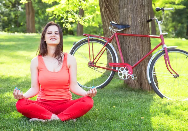Happy girl in the park with bicycle on background. — Stock Photo, Image