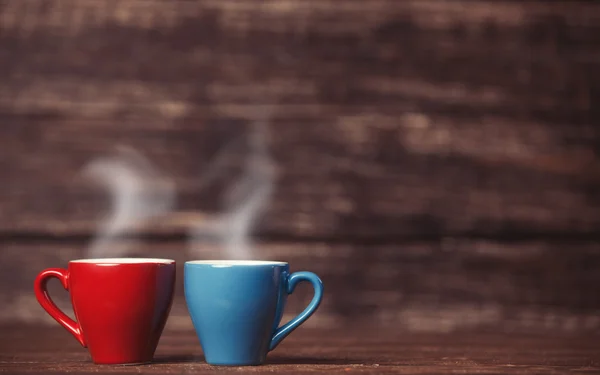 Dos tazas de té o café en una mesa de madera . — Foto de Stock