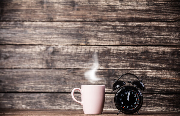 Tea or coffee cup and alarm clock